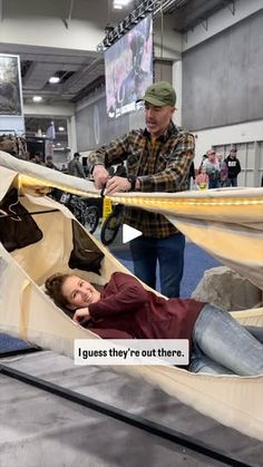 a woman laying in a hammock next to a man