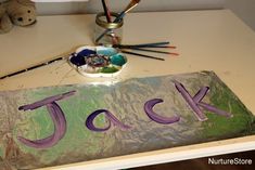 there is a sign that says jack on the table next to some paintbrushes