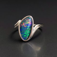 "Natural Australian black Opal triplet Sterling Silver Ring, one-off piece of natural opal set in sterling silver in a modern design.  Simple design with a pop of rainbow colour in this unique opal ring.  💎 Main Gemstone: Natural Australian Black Opal 💎 Material: Solid British Sterling Silver with rhodium plating.  Please note: All my Australian black Opals are one-off pieces so some rings will need to be resized to your size once the order is placed, please allow 4-5 working days for me to ch Silver Opal Ring With Polished Finish, Black Cabochon Opal Ring, Unique Opal Ring, Black Fire Opal, Natural Opal Ring, Unique Opal, Australian Black Opal, Rainbow Colour, Cosmic Consciousness