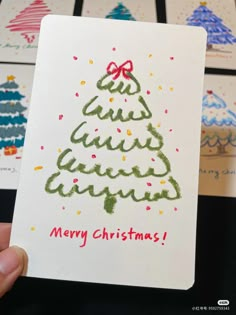 a hand holding up a christmas card that says merry christmas