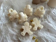 some white candles that are sitting on a piece of wax paper with gold decorations around them