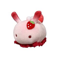 a small stuffed animal with a strawberry on it's head, sitting in front of a white background