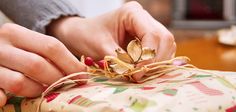 a woman is wrapping a present with twine on the table next to a fireplace