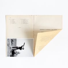 an open book with pictures and text on the pages, sitting on top of a white surface