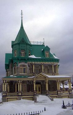 a large building with a green roof covered in snow