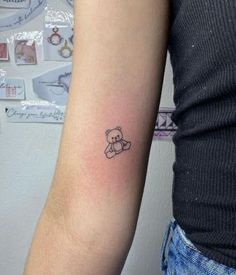 a small teddy bear tattoo on the arm