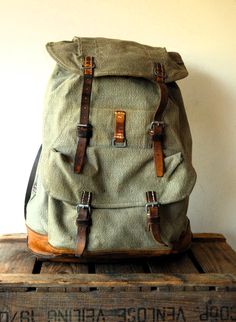 Swiss Army Backpack from 1964, made from canvas and leather. < < < P R O D U C T D E S C R I P T I O N > > > Perhaps the best military canvas rucksack of all time and certainly the most sought-after, this is the 1950's canvas and leather Swiss Army Backpack . The design was so successful it remained in use for decades even being re-made using a ballistic nylon material as seen in the Swiss Backpack from the 1980's. The Swiss Army Backpack has tough forged anodised metal fixings, thick leather an Retro Standard Backpack For Outdoor, Vintage Backpack With Leather Handles Satchel, Vintage Satchel Backpack With Leather Handles, Vintage Leather Handle Satchel Backpack, Retro Outdoor Standard Backpack, Vintage Adventure Bags With Leather Backing, Everyday Vintage Backpack With Leather Handles, Vintage Adventure Bags, Vintage Standard Backpack For Adventure