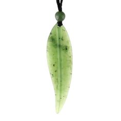 a green leaf shaped pendant hangs from a black cord