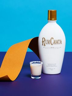 a bottle of rumchata next to a shot glass and paper on a table