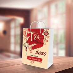 a red and white shopping bag with chinese writing on it sitting on top of a wooden table