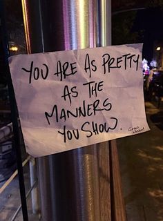 a sign on a pole that says you are as pretty as the manners you show