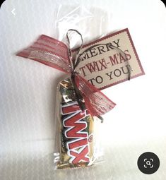 a candy bar wrapped in red and white paper with a tag that says merry twx - mad to you