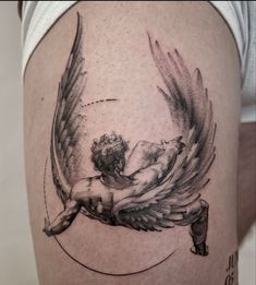 an angel tattoo on the side of a woman's thigh