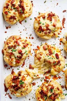 baked biscuits covered in cheese and bacon on a baking sheet