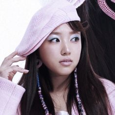 a woman with long dark hair wearing a pink hat and beads on her head is posing for the camera