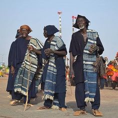 three men in traditional african clothing standing next to each other