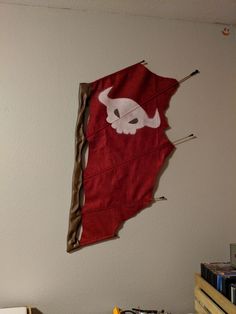 an upside down kite hanging on the wall in a room with books and other items