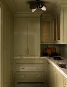 a kitchen with green cabinets and a ceiling fan