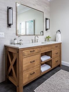 a bathroom with two sinks and a large mirror on the wall above it is also a rug