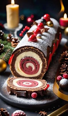 a christmas cake roll on a platter with candles and decorations