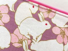 "This zipper pouch is made from Japanese cotton print. It is 100% cotton imported from Japan. This bag features white bunnies and a pink camellia on a lavender background with a metallic gold embellishments. Fully lined with Japanese cotton fabric of a pink with a pin dot pattern. Zipper is hot pink and the zipper pull is accessorized with a gold flower shaped charm. Perfect purse for keeping small items such as compact digital camera, iPod, credit cards, etc. Dimensions (approx): 3.5\"L x 5\"W White Zipper Pouch Pencil Case For Daily Use, White Zipper Pouch Pencil Case, White Rectangular Zipper Pouch, White Pencil Case With Zipper, White Cosmetic Bag With Zipper Pocket For Daily Use, White Rectangular Pouch With Zipper Pocket, White Zipper Pouch For Personal Use, White Rectangular Zipper Pencil Case, White Pencil Case With Zipper Closure As Gift