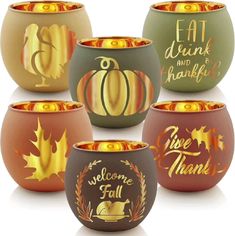 four different colored bowls with pumpkins and leaves painted on the sides, all decorated in gold