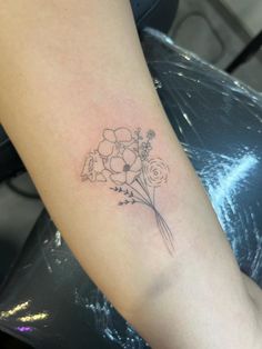 a woman's arm with a flower tattoo on the left side of her arm