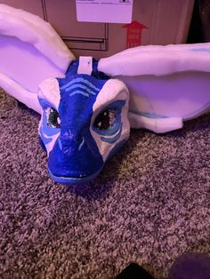 a blue and white dragon mask laying on the floor