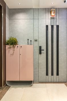 a pink cabinet sitting in the middle of a room next to a planter and door