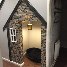 a dog house made out of bricks with a cat bed in the doorway to it