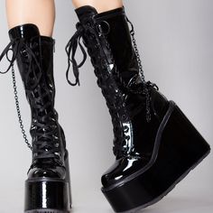 Bring In A New Era Of Fear With The Dark Age Platform Boots From Demonia. These Sinful Festival Boots Feature A Black Vegan Patent Leather Upper With Lace Up Front, Wedge Heel, O Ring And Chain Accents, And Interior Zipper Closure. Throw On These Heinously Cute Boots And Let Chaos Reign. Dark Age Platform Boots 5 1/2"" Wedge Platform Vegan Patent Leather Lace-Up Front Stretch Knee High Boot Removable Metal Chain Detail Inside Metal Zip Black Black High-top Wedge Boots With Chunky Platform, Black Lace-up Wedge Boots With Chunky Platform, Black Lace-up Chunky Platform Wedge Boots, Black Ankle-high Wedge Boots With Chunky Platform, Party Synthetic Wedge Boots With Round Toe, Round Toe Synthetic Wedge Boots For Party, Streetwear Patent Leather Platform Boots With Round Toe, Black Chunky Platform Lace-up Boots, Black Ankle-high Wedge Boots For Streetwear