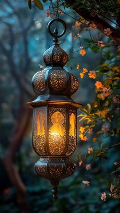 a lantern hanging from a tree with flowers in the background