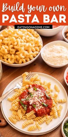 pasta with sauce and parmesan cheese is on a white plate next to other dishes