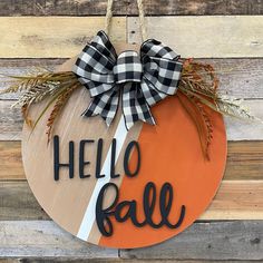 a wooden sign that says hello fall with a black and white bow hanging from it