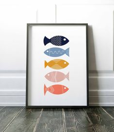 an art print with four fish in different colors and sizes on the wall next to a wooden floor