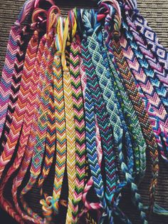 many different colored braids are lined up on the floor with one knot in the middle