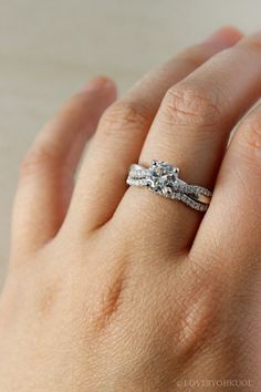 a woman's hand with a wedding ring on her left hand and an engagement band in the middle