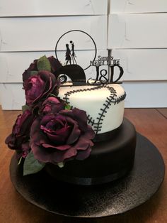 there is a cake decorated with baseball and roses on the table next to a white wall