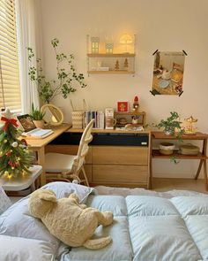 a teddy bear sitting on top of a bed next to a desk