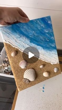 someone is painting seashells on the sand