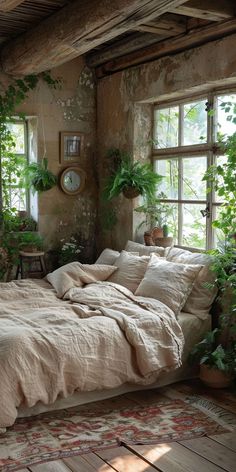 a bed sitting in a bedroom next to two windows with potted plants on them