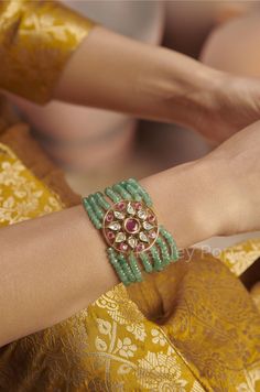 The sage green polki bracelet is a harmonious fusion of heritage and contemporary forms of Indian jewelry. The traditional red and green bracelet is handcrafted by the artisans of India to celebrate perfect armor between old and modern concepts. The beaded polki bracelet is a beautiful work of art with a royal touch to adorn your wrist and be a companion on your special days. Pair this statement piece with your Indian or contemporary ensemble and complete the look. Closure - Lobster. Style Tip - Fusion Meenakari Bracelets For Festivals, Fusion Style Meenakari Bracelets For Festivals, Fusion Style Kundan Bracelets With Cutdana, Traditional Green Meenakari Bracelets, Festive Fusion Gemstone Bracelets, Green Meenakari Bracelets For Festivals, Traditional Green Cutdana Bracelets, Traditional Green Kundan Bracelet, Temple Jewelry Gemstone Bracelets For Festivals