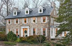 a stone house with wreaths on the windows