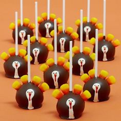 there are many candy balls with candles in the shape of turkeys on top of them