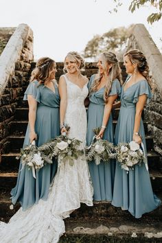 the bride and her bridesmaids are standing on some steps