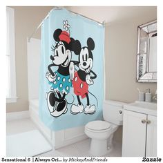 a mickey and minnie mouse shower curtain in a bathroom with a toilet, sink, and mirror