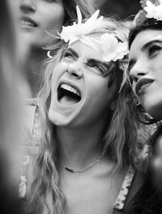 two women with flower crowns on their heads and one woman holding her cell phone up to her ear