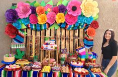 a woman standing in front of a colorful table