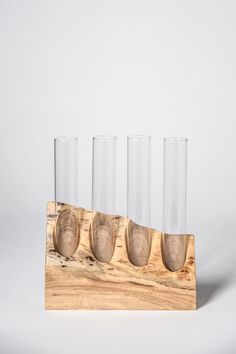 four glasses are lined up on a wooden stand