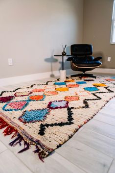 an area rug on the floor with a chair and lamp